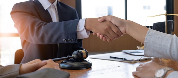 Foto empresário apertando as mãos para selar um acordo com seus advogados parceiros ou advogados discutindo um acordo de contrato