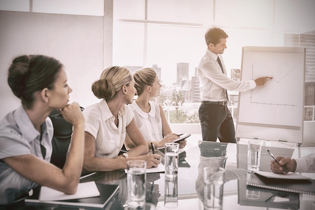 Foto empresário apontando para um gráfico crescente durante uma reunião