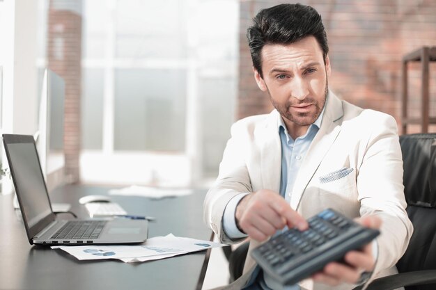 Empresario apuntando a la calculadora en la manoPresentación del informe anual