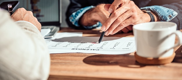 Empresario apuntando a una fecha específica en un calendario