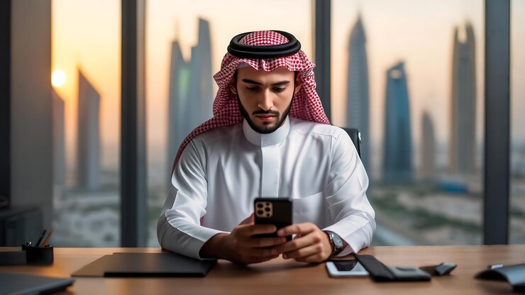 Empresario árabe en la oficina usando el teléfono inteligente con Cityscape View