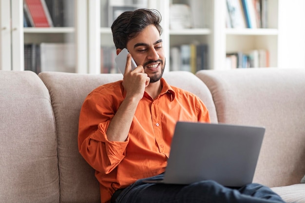 Empresario árabe rico que trabaja desde casa usando una computadora portátil