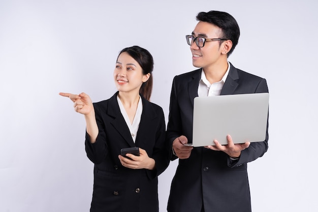 Empresário asiático e mulher de negócios usando laptop em fundo branco