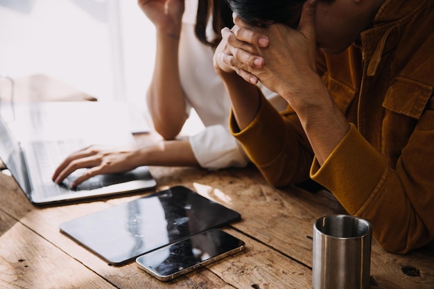 Empresário asiático empresário e empresária discutindo novo projeto de negócios em tablet em reunião moderna no conceito casual de negócios asiáticos de escritório moderno