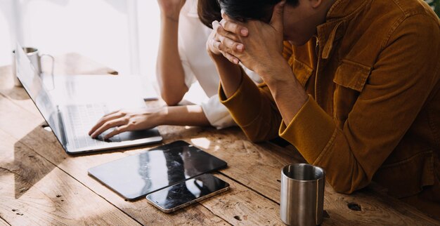 Empresário asiático empresário e empresária discutindo novo projeto de negócios em tablet em reunião moderna no conceito casual de negócios asiáticos de escritório moderno