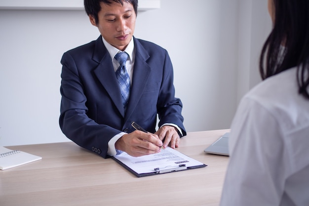 Empresário asiático entrevistando um novo funcionário. o chefe de rh está perguntando sobre o histórico de empregos e as habilidades dos candidatos. conceito de entrevista de emprego