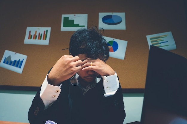 Foto empresario asiático bajo estrés debido al exceso de trabajosentirse exhaustoel empleado joven tiene un problema en una oficinahombre triste del trabajoconcepto de hombre desordenado enojado