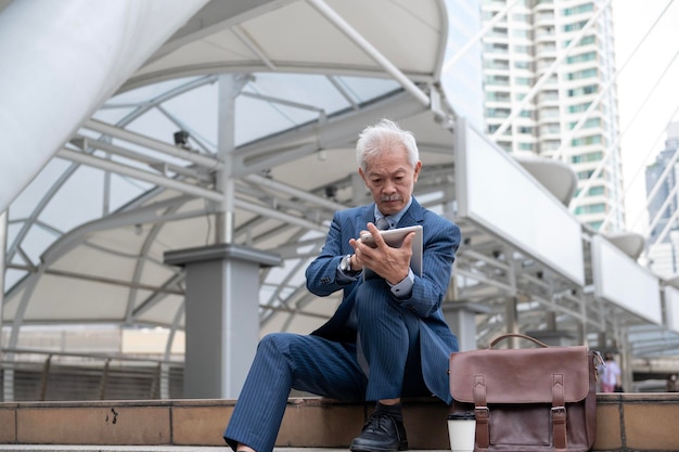 Empresário asiático sênior de meia-idade se sentindo preocupado e frustrado na cidade moderna