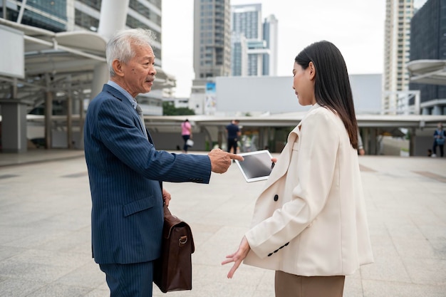 Empresário asiático sênior maduro de meia-idade e jovem empresária discutindo