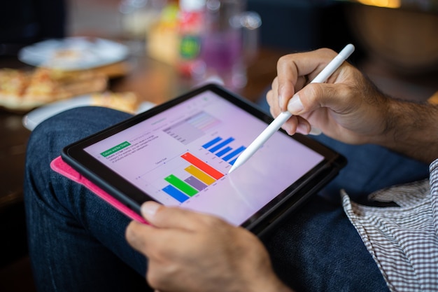 Empresario asiático con tableta para trabajar en la cafetería.