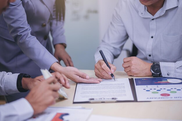 Foto empresário assina contrato em reunião de negócios após negociações com parceiros de negócios