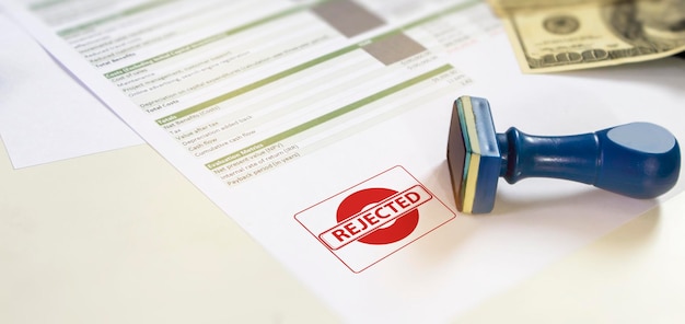 Empresário assinando um selo de rejeição de projeto de negóciosFalha em passar documentos financeiros Empréstimo e jurosempréstimo financeiro