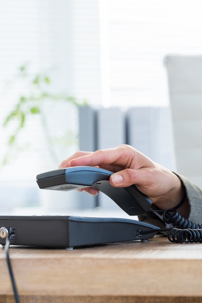 Foto empresário atender o telefone no escritório