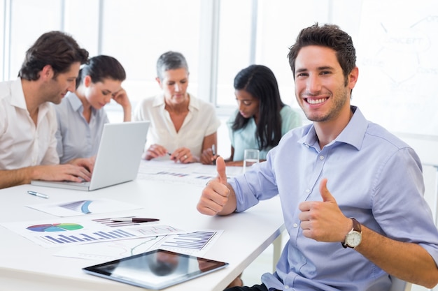 Empresario atractivo sonriendo en el lugar de trabajo