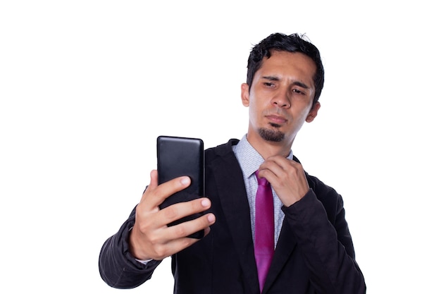 Empresário atraente posando e tirando uma foto com seu celular Jovem adulto latino jovem isolado no fundo branco