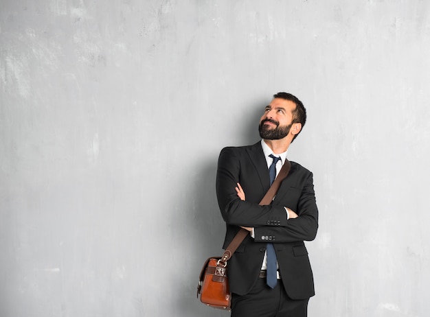 Empresario con barba mirando hacia arriba mientras sonríe