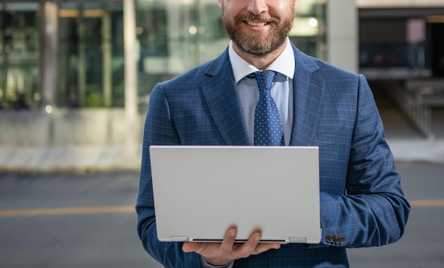 Empresário barbudo sorridente cortado em terno formal trabalhando online em redes de computadores