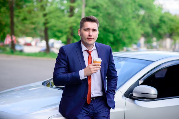 Empresário bebendo café no carro.