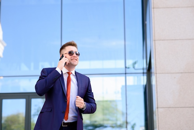 Empresário bem sucedido, falando ao telefone e sorrindo.