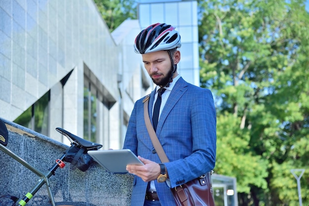 Empresario con bicicleta mediante tableta digital