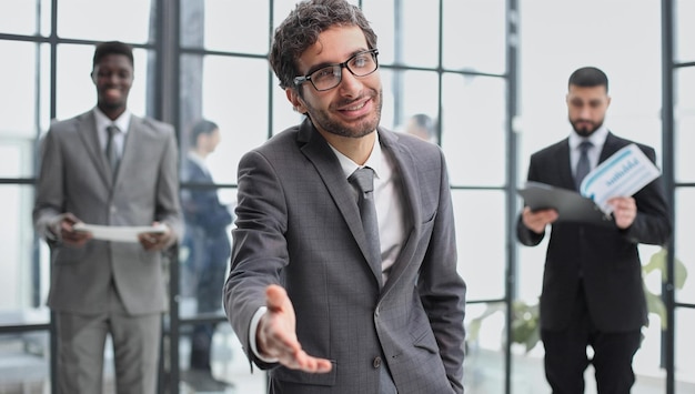 Foto empresário bonito do conceito de negócios e escritório com mão aberta pronta para aperto de mão