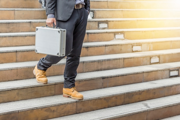 Empresario caminando por las escaleras con bolsas a la oficina