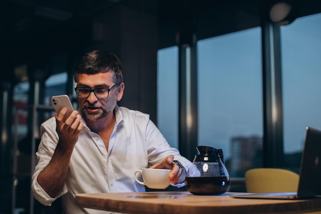 Empresário cansado derrama café na mesaxA