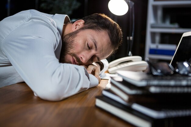 Empresario cansado durmiendo en el escritorio