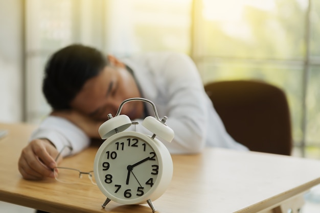 Foto empresario cansado durmiendo en la mesa hasta la mañana.