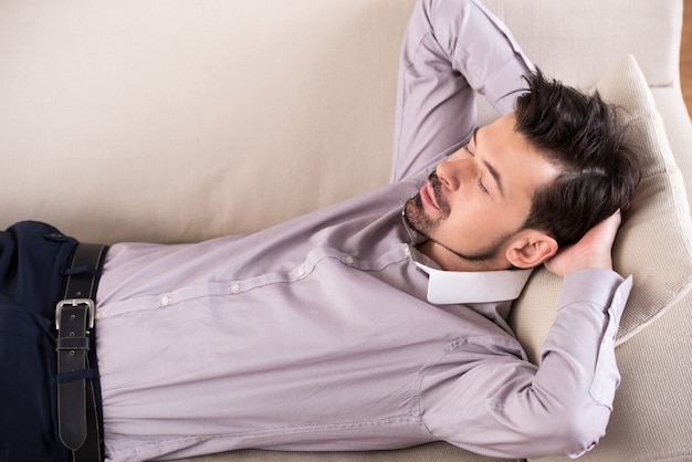 Foto empresario cansado está durmiendo en el sofá de la oficina.