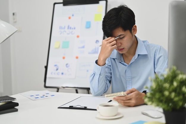 Empresário cansado segurando a cabeça nas mãos exausto de excesso de trabalho ou estresse no trabalho