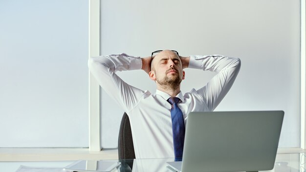 Empresario cansado sentado en el escritorio de oficina