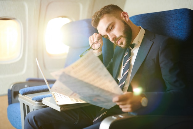 Empresario cansado trabajando en avión