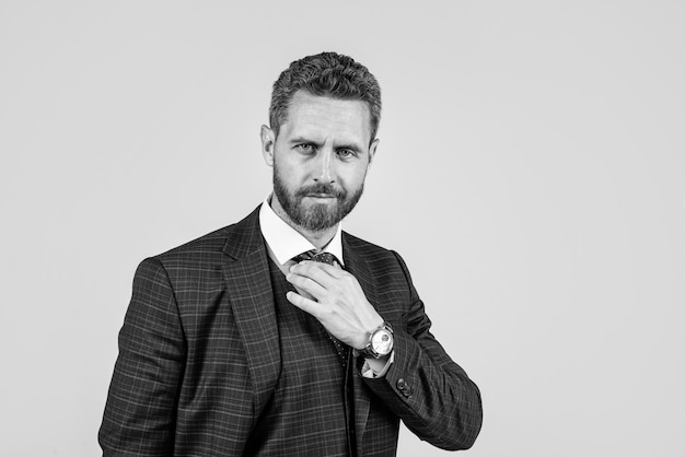 Empresário carismático de terno formal conserta gravata copia espaço beleza masculina