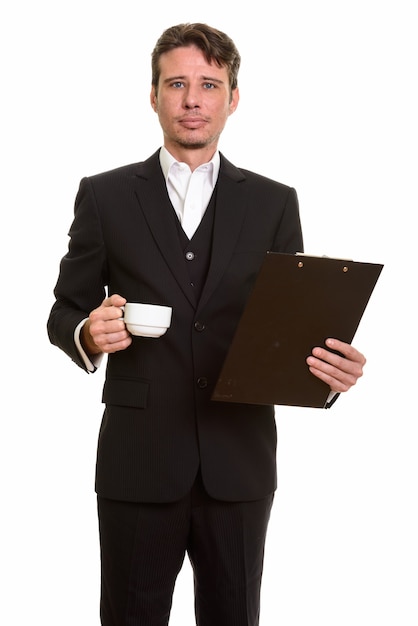 Empresário caucasiano bonito segurando uma prancheta e uma xícara de café