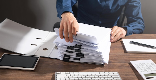 Foto empresário caucasiano segurando documentos no escritório