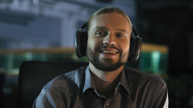 Empresario caucásico feliz exitoso satisfecho sonriente hombre de negocios con auriculares inalámbricos