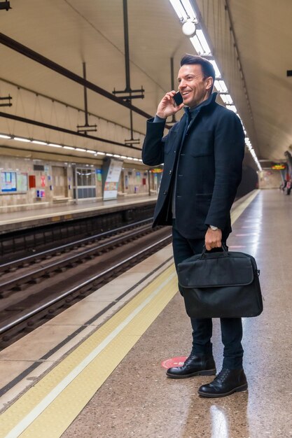 Empresario caucásico de mediana edad esperando en el metro el tren para ir a trabajar