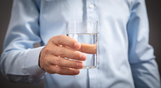 Empresario caucásico sosteniendo un vaso de agua