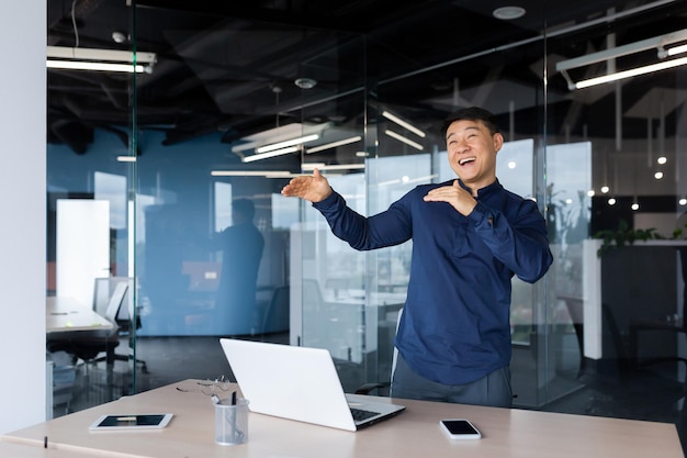 Empresario celebrando el logro hombre asiático bailando y cantando en el lugar de trabajo hombre con camisa trabajando