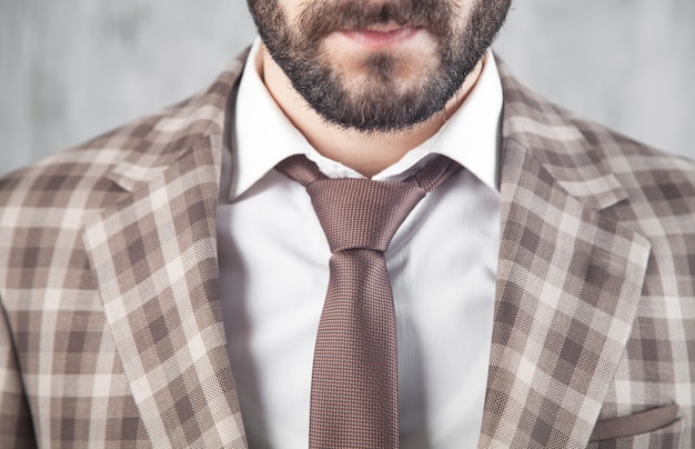 Foto empresario con chaqueta y corbata marrón.