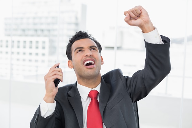 Empresário cheering com o punho cerrado enquanto ele olha para cima