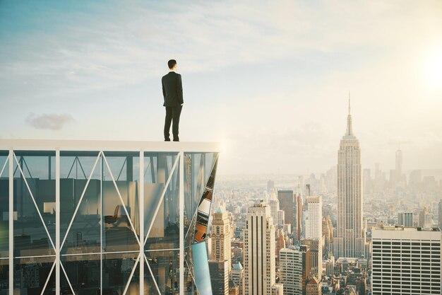 Empresario en la cima de un rascacielos mirando la ciudad