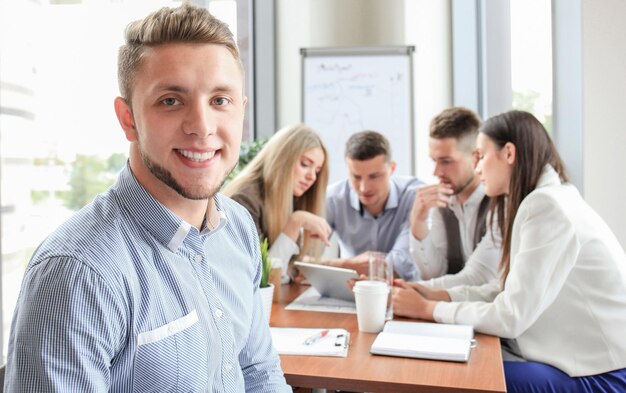 Empresario con colegas en segundo plano en la oficina