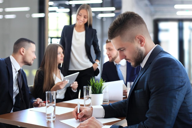 Empresario con colegas en segundo plano en la oficina