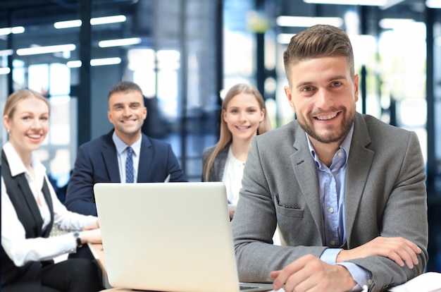 Empresario con colegas en segundo plano en la oficina