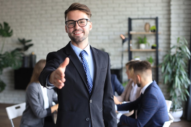 Empresário com a mão aberta pronta para selar um acordo.