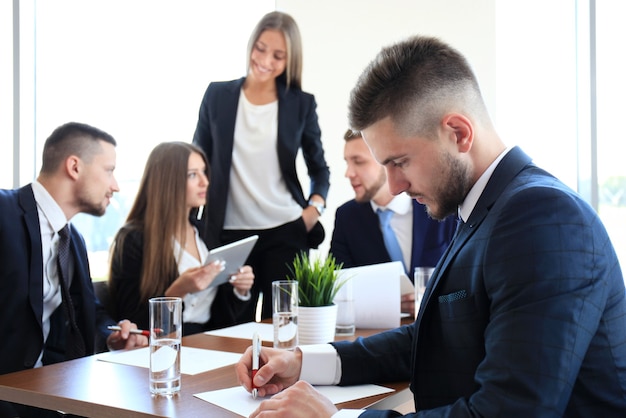 Empresário com colegas em segundo plano no escritório