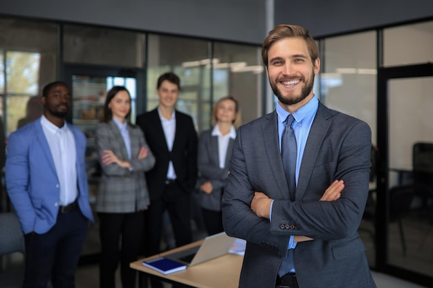 Empresário com colegas em segundo plano no escritório.