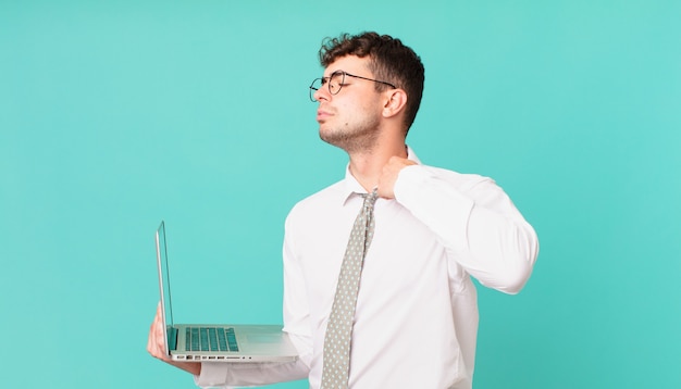 Empresário com laptop se sentindo estressado, ansioso, cansado e frustrado, puxando o pescoço da camisa, parecendo frustrado com o problema